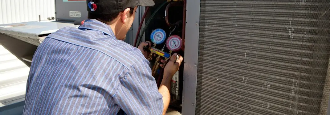 HVAC technician servicing a condenser unit in Cypress Lake